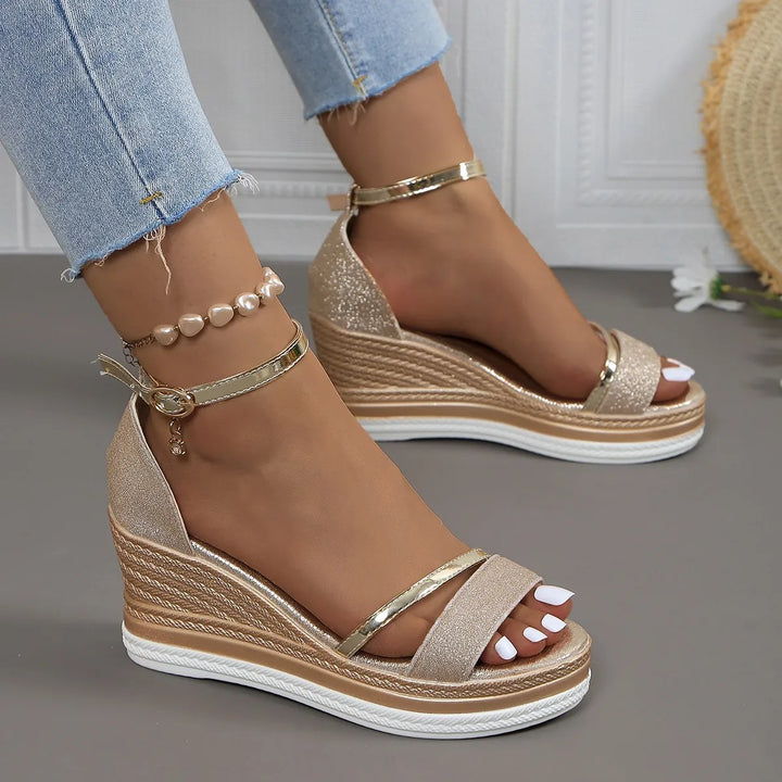 Women's golden open toe wedge sandals with two front straps and a visible ankle strap buckle.