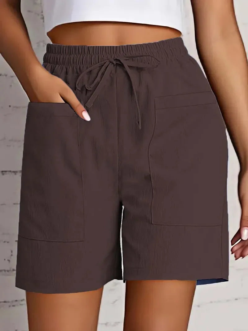Women brown casual shorts with elastic waist, drawstring, and two large front patch pockets, mid-thigh length.