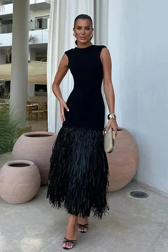 Women black sleeveless feathered midi dress on model, front view with a gold clutch and cuff bracelet