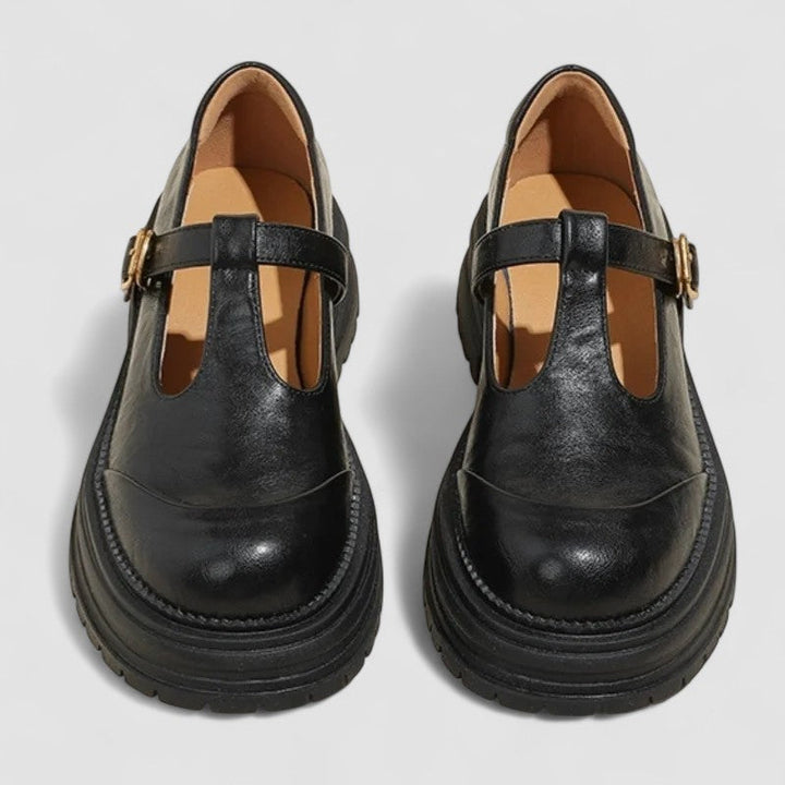 Two black classic buckle mary jane platform shoes side by side, front view.