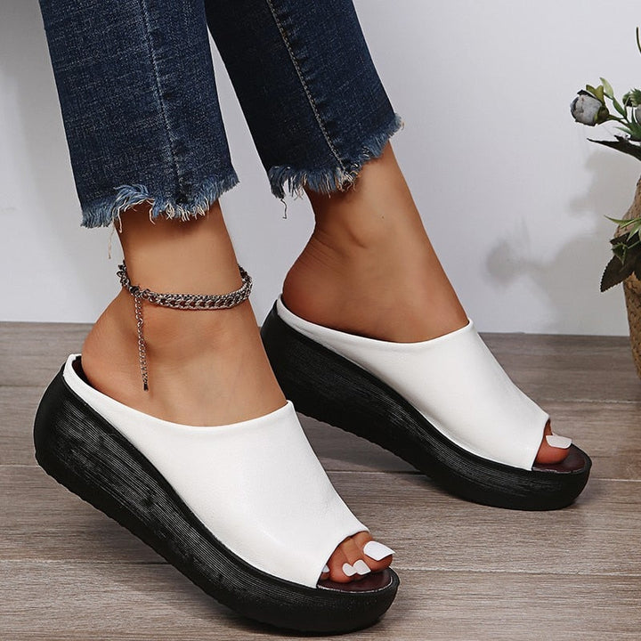 Women's white open toe platform slide sandals with black sole and dark footbed, side profile
