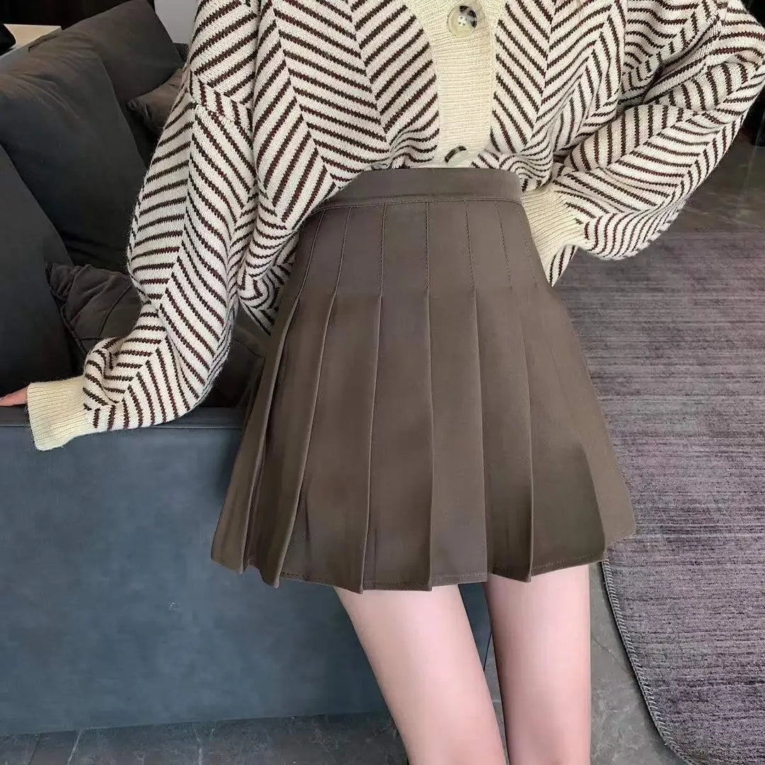 Women brown high waist pleated mini skirt, front view, styled with a patterned cardigan.