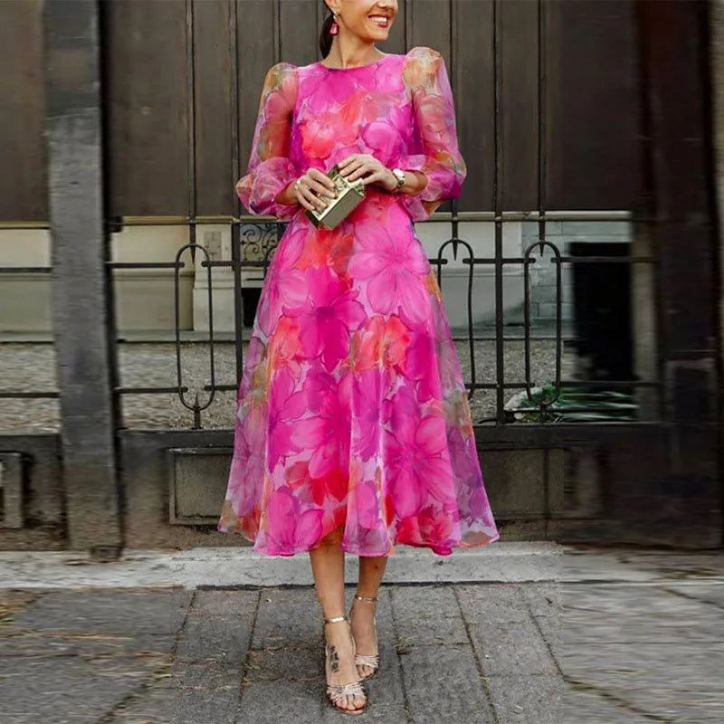 Women pink floral print long sleeve midi dress with round neckline, front view with handbag