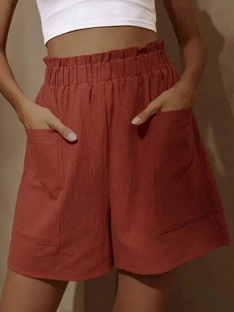 Women's terracotta high waist paperbag shorts with large front pockets and relaxed fit.