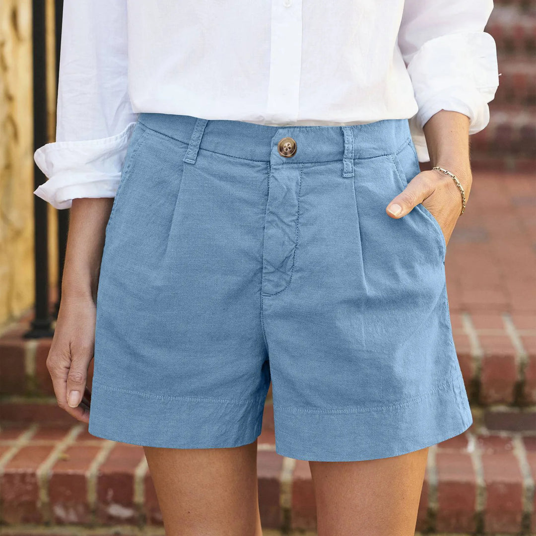 Women light blue high waisted pleated shorts with side pockets and a white shirt