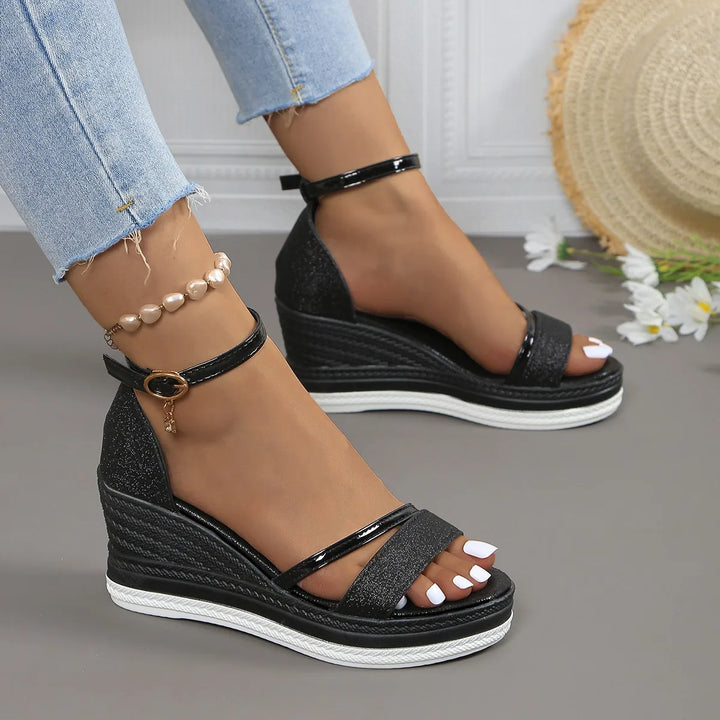 Women's black open toe wedge sandals with a glossy front strap and buckle ankle strap.