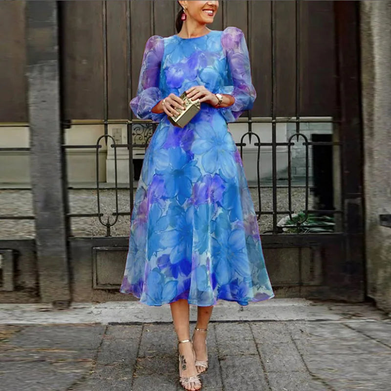 Women blue floral print long sleeve midi dress with round neckline, front view with handbag