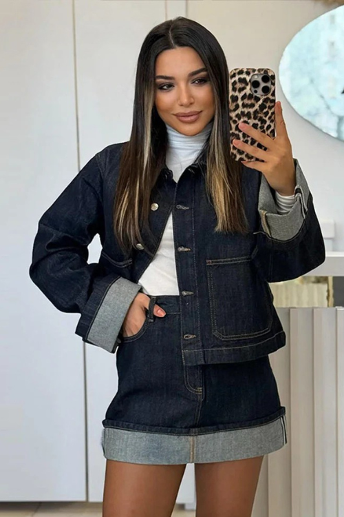 Women dark wash denim cropped jacket and mini skirt set worn with white turtleneck, front view.