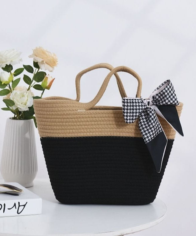 Women two-tone beige and black woven tote bag with a houndstooth scarf tied on handle, front view.
