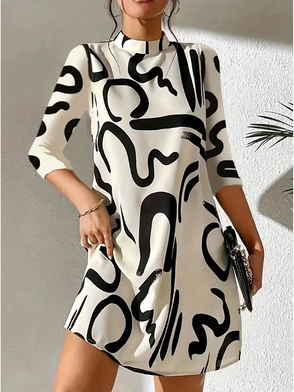 Women white and black printed mini dress with 3/4 sleeves, front view on model.