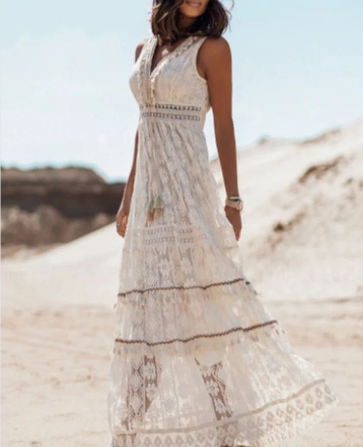 Women white sleeveless V neck lace maxi dress, full-body view walking on sand showing flowing tiered skirt.