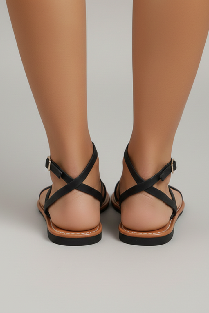 Back view of women's black flat sandals with ankle straps and buckles