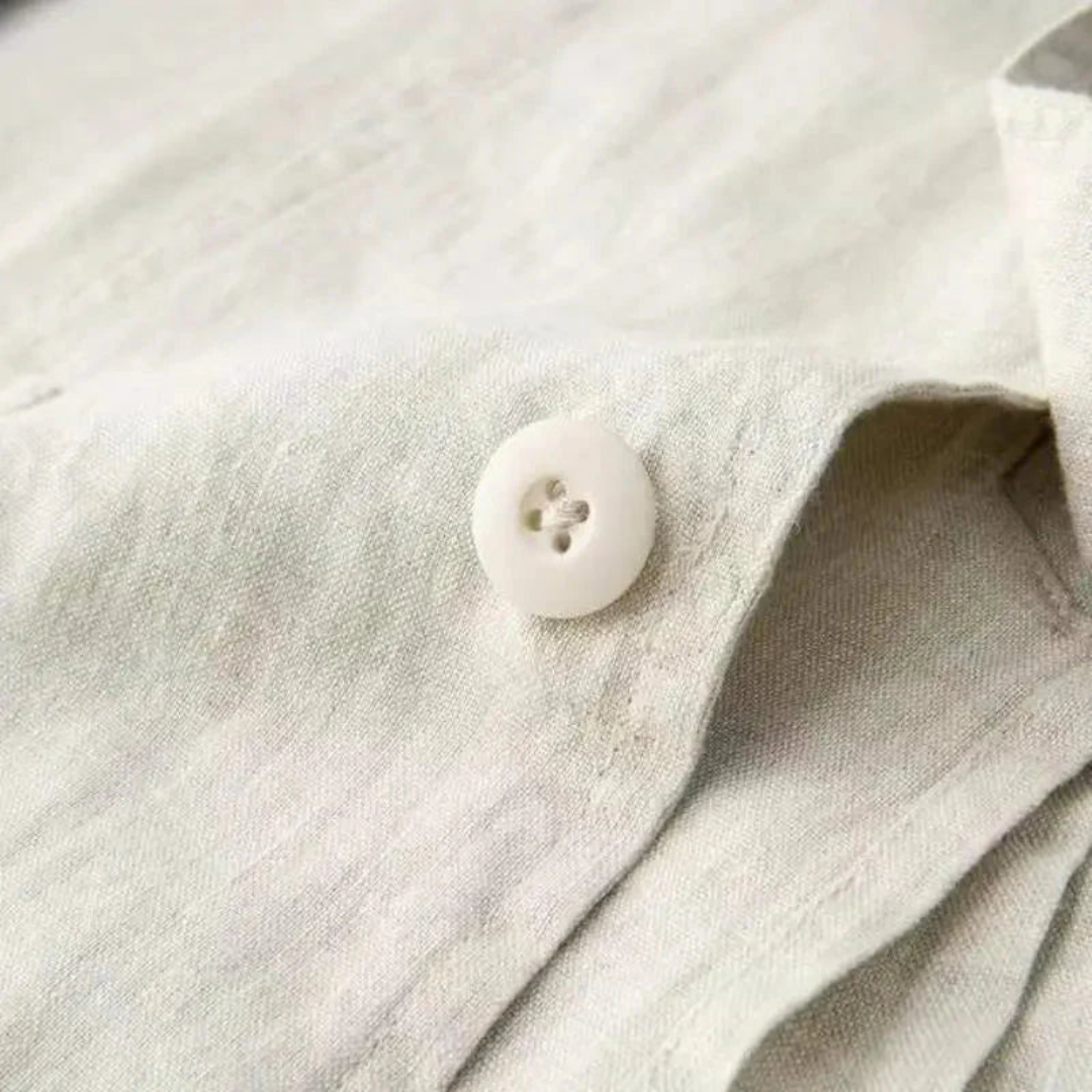 Close-up of beige linen fabric texture with white four-hole button on blazer