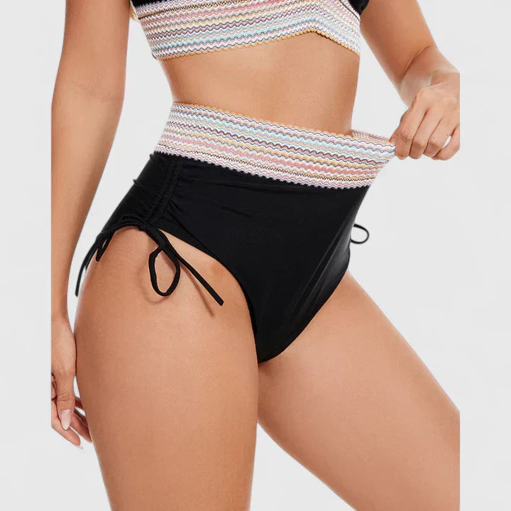 Close-up of black bikini bottoms with multicolor striped waistband and ties