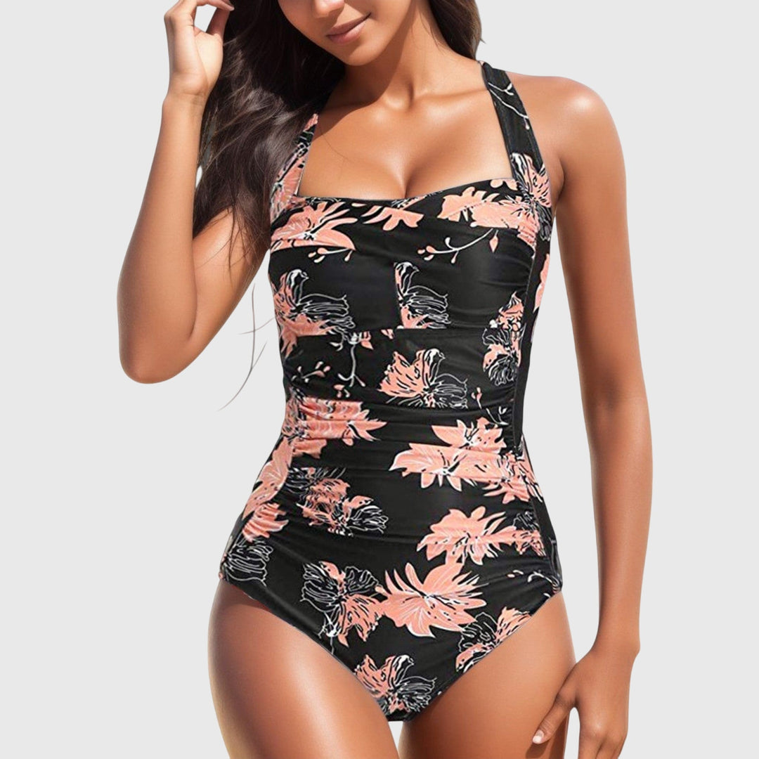 Black one-piece swimsuit with coral and pink floral print and ruching