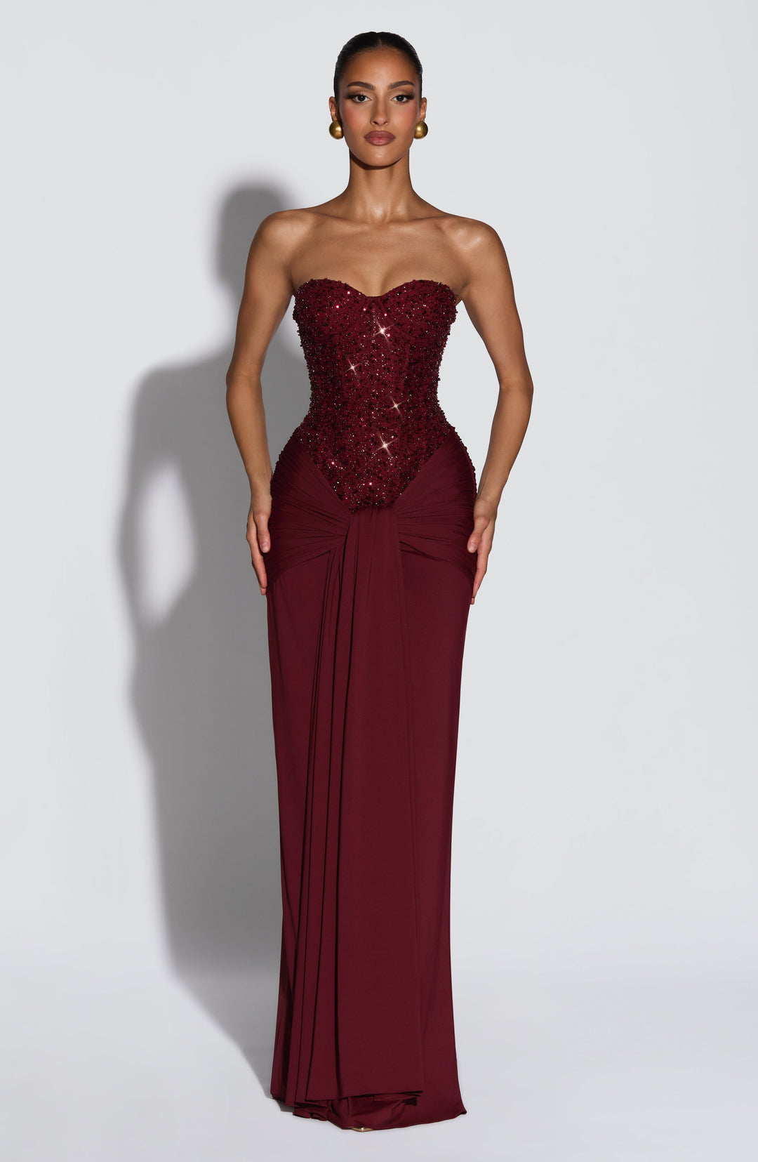 Women burgundy strapless sequin maxi dress with knotted waist detail shown from front