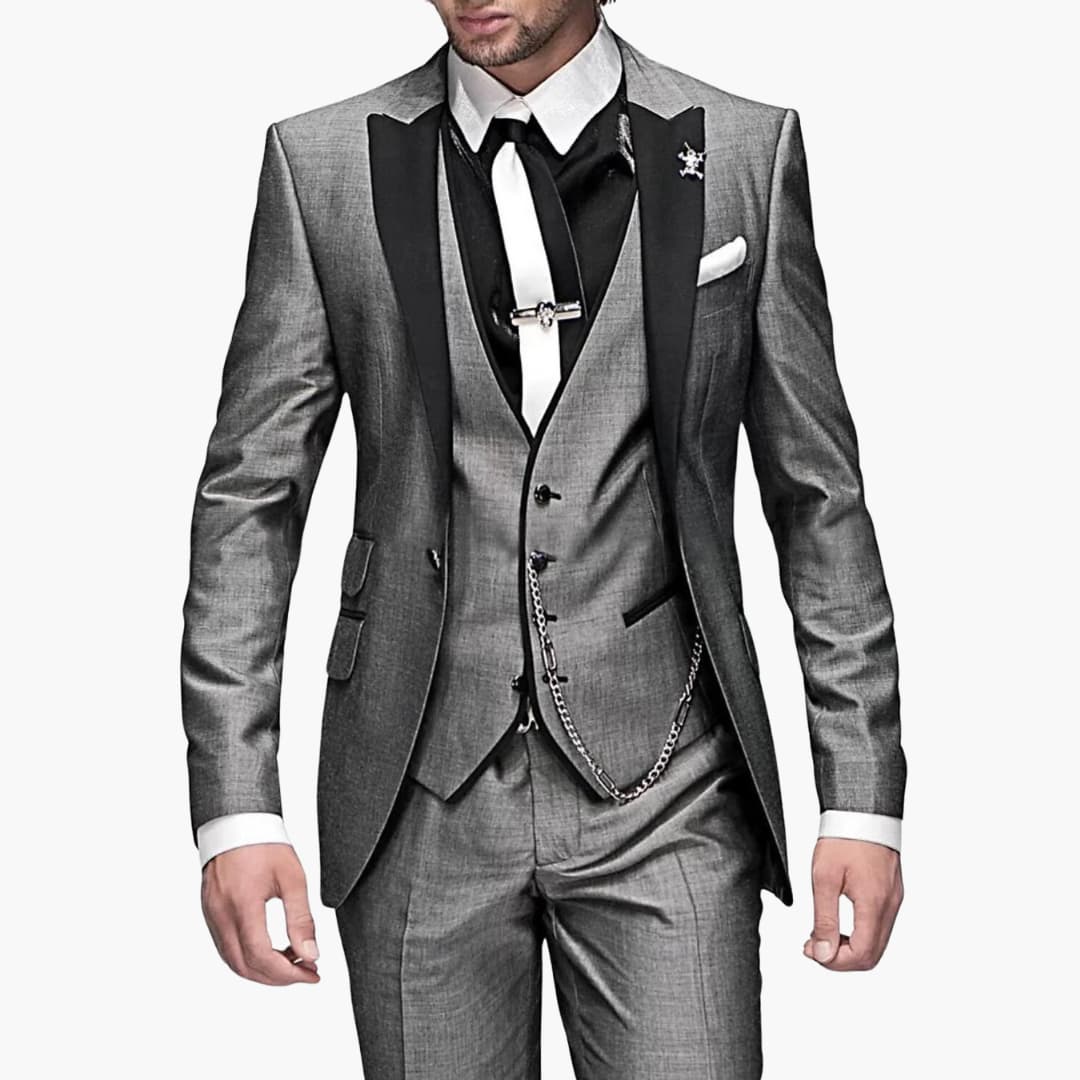 Charcoal gray three-piece suit with notch lapel blazer, black vest, and chain detail for formal events