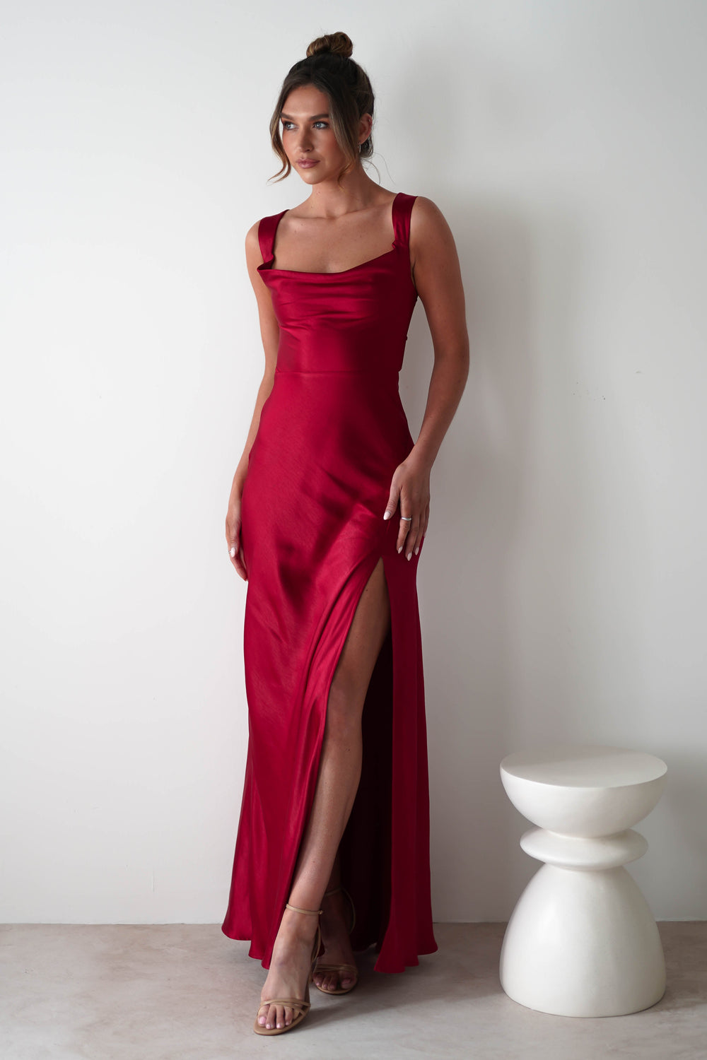 Women red satin cowl neck maxi dress with thick straps and thigh-high side slit showing detail.