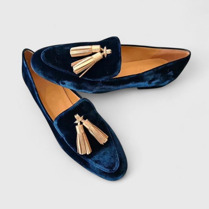 Women blue velvet loafers with gold tassels on a white background, top view