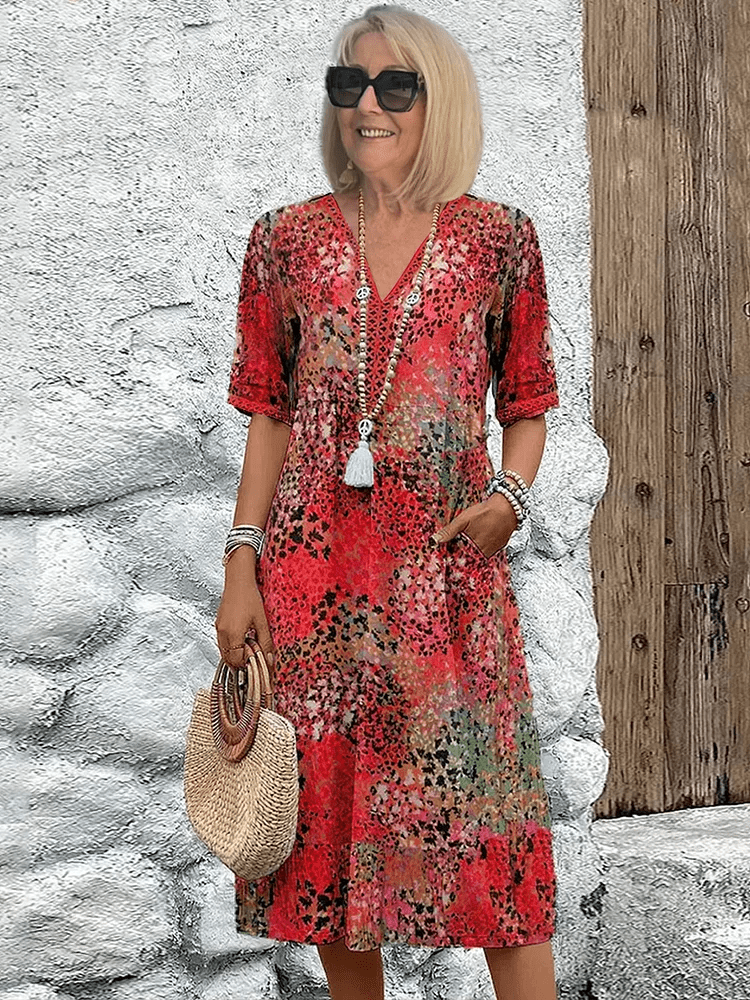 Women's red multi-color printed midi dress with V-neck and short sleeves, standing pose.