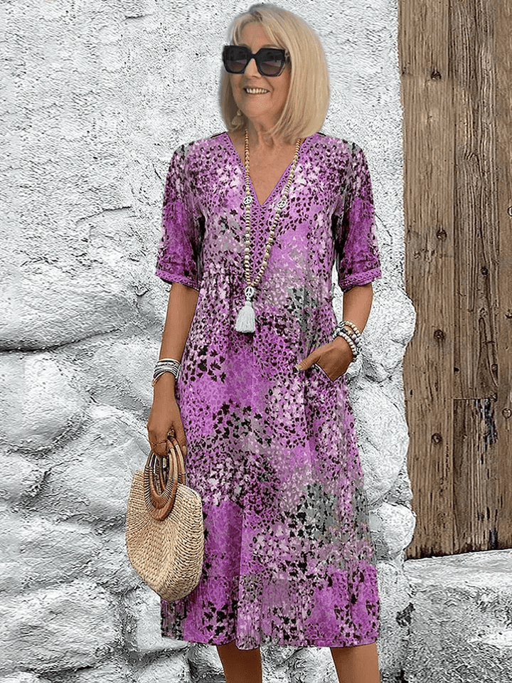 Women's purple multi-color printed midi dress with V-neckline and loose flowing silhouette.