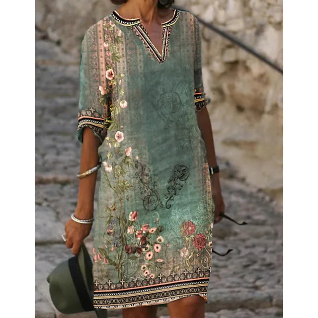 Women green floral mini dress with V-neckline and short sleeves, standing outdoors.