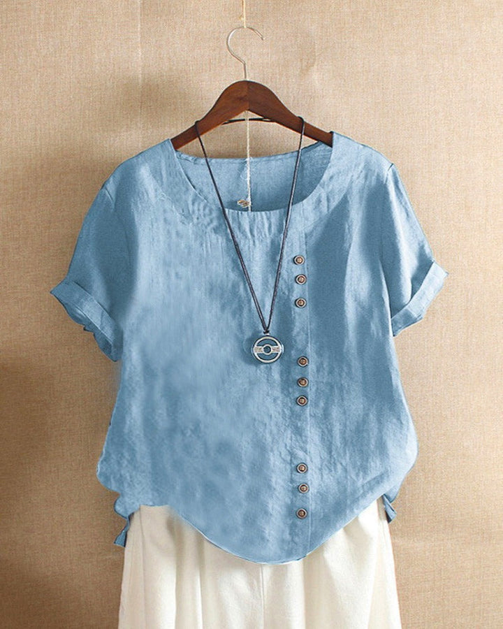 Women light blue short sleeve blouse with round neck and offset button detail on hanger
