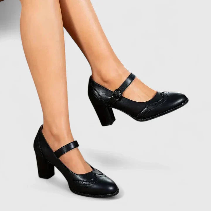 Women black Mary Jane block heels with a rounded toe and buckled strap on a model's feet.