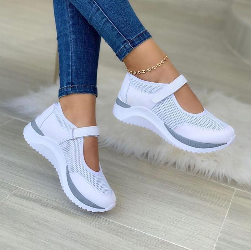 Women's white mesh Mary Jane sneakers with gray sole accents, displaying the hook-and-loop strap and breathable material.