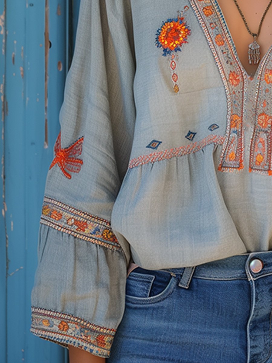 Detail view of the lantern sleeve with embroidered cuff on the women's light blue blouse