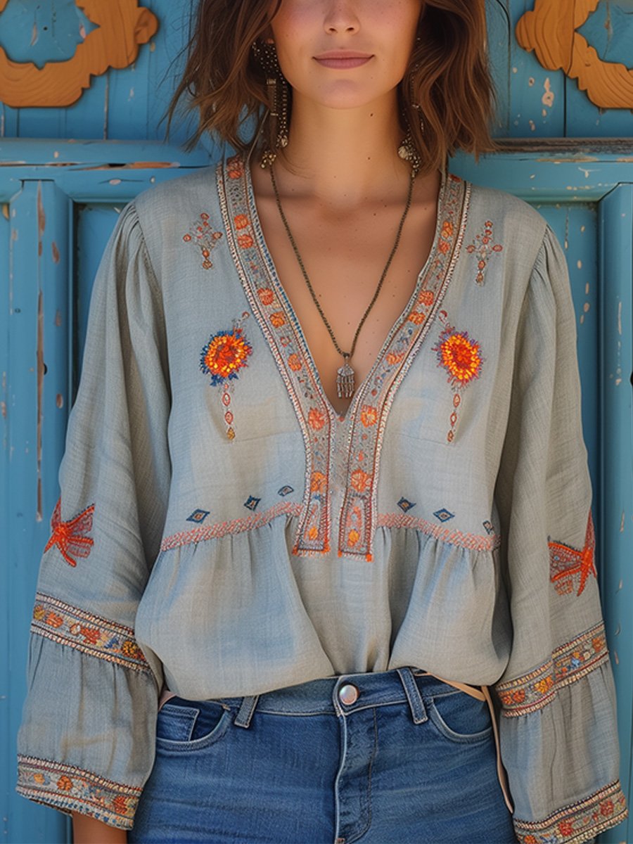 Women light blue embroidered V-neck blouse with long lantern sleeves, front view with necklace