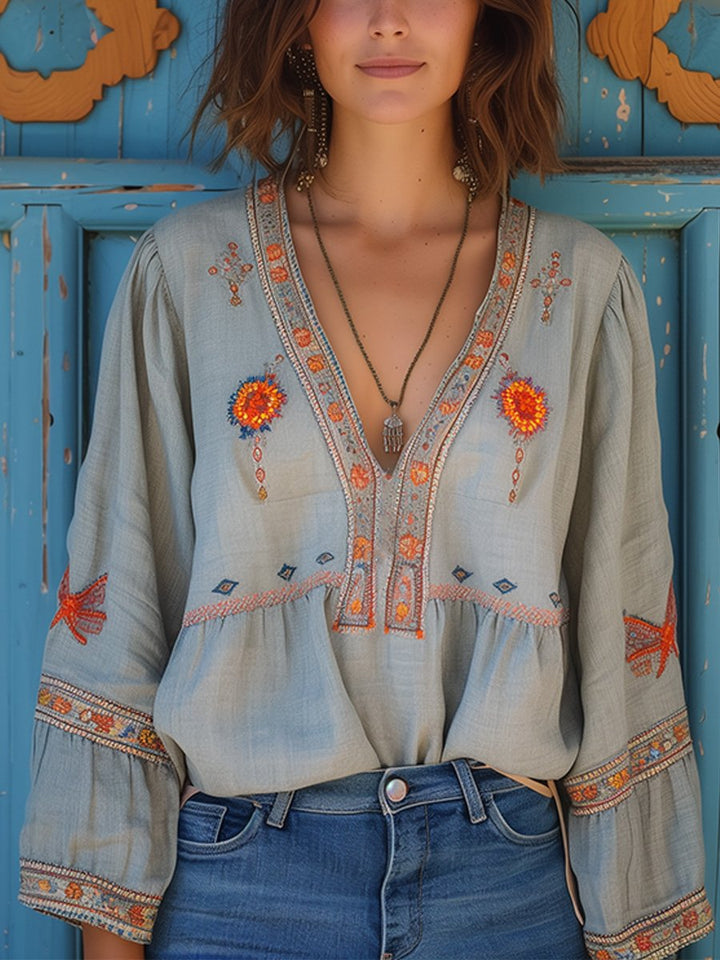 Women light blue embroidered V-neck blouse with long lantern sleeves, front view with necklace