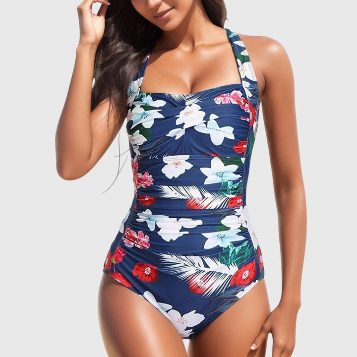Navy one-piece swimsuit with white and red tropical flowers and ruched details