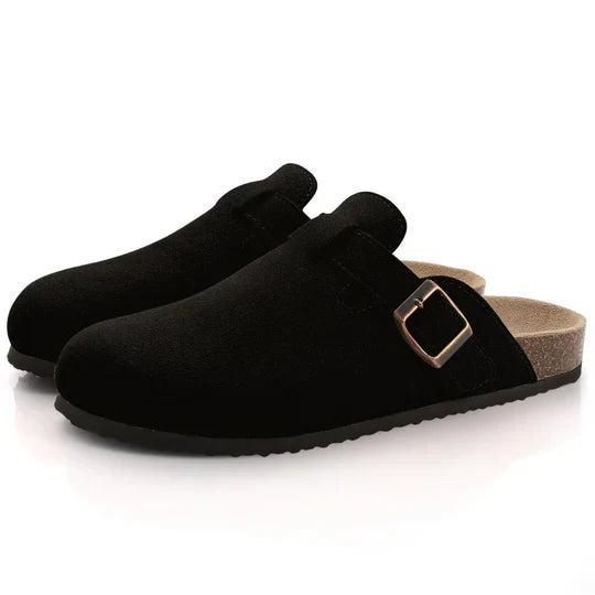 Pair of black suede-like cork buckle slide slippers with dark soles, side view