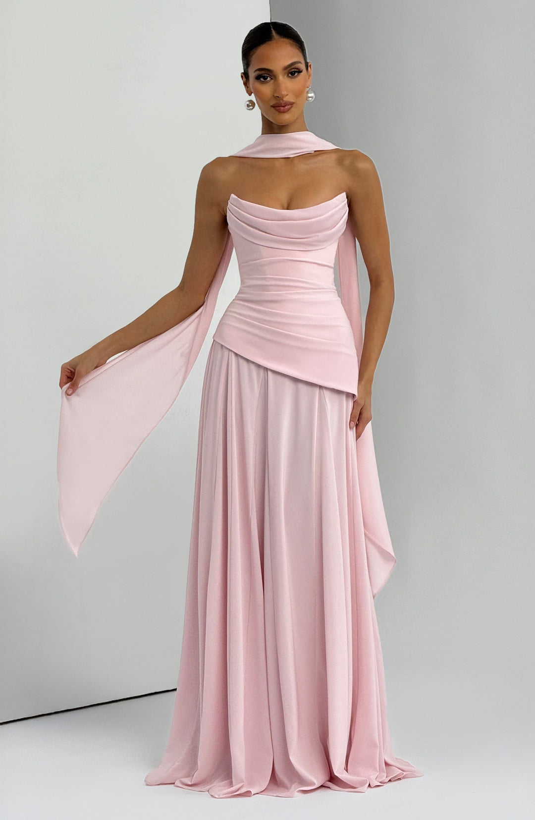 Women light pink strapless cowl neck maxi dress with chiffon draped detail and full skirt, posed