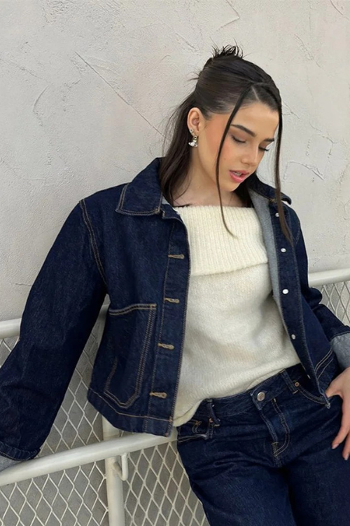 Women dark wash denim cropped jacket with wide cuffs, worn with an off-shoulder top.