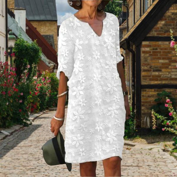 Women's white floral V neck mini dress with short sleeves, front view on model outdoors