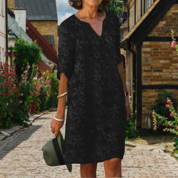 Women's black floral V neck mini dress with short sleeves, front view on model walking