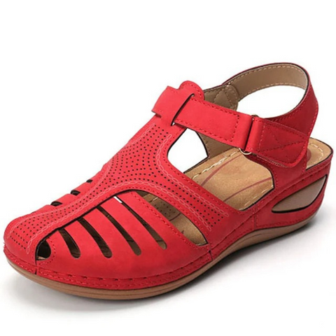 Close-up of a single red strappy closed toe wedge sandal with visible stitching and adjustable strap