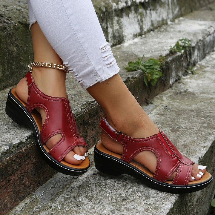Burgundy red adjustable cut-out strappy sandal with brown inner lining and gold chain ankle bracelet