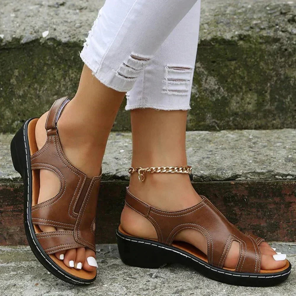 Brown leather adjustable cut-out strappy sandal with black sole and chain ankle bracelet