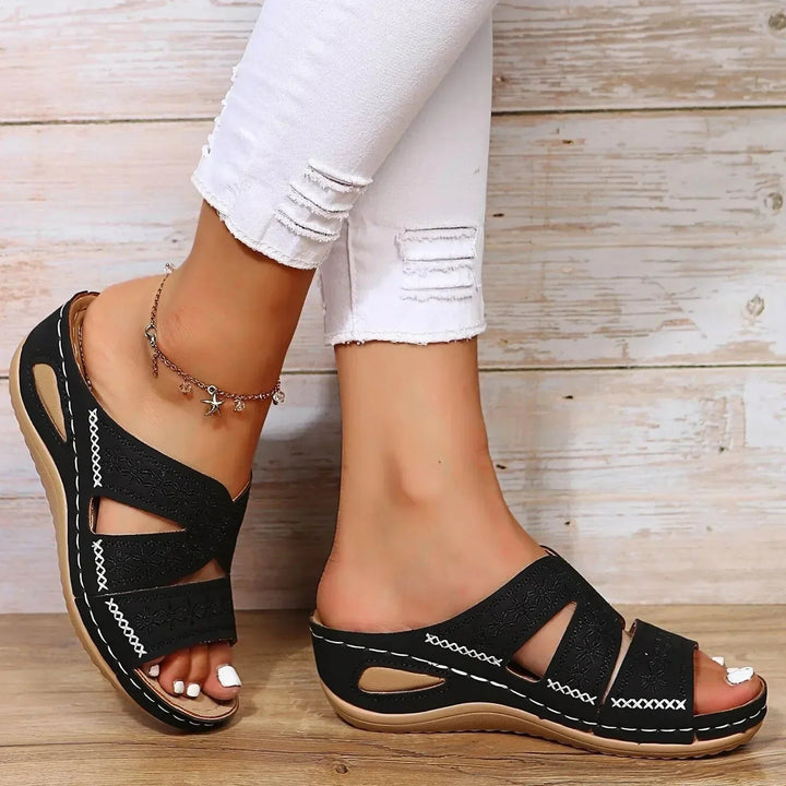 Black adjustable wedge platform slide sandals with embroidered straps and white contrast stitching