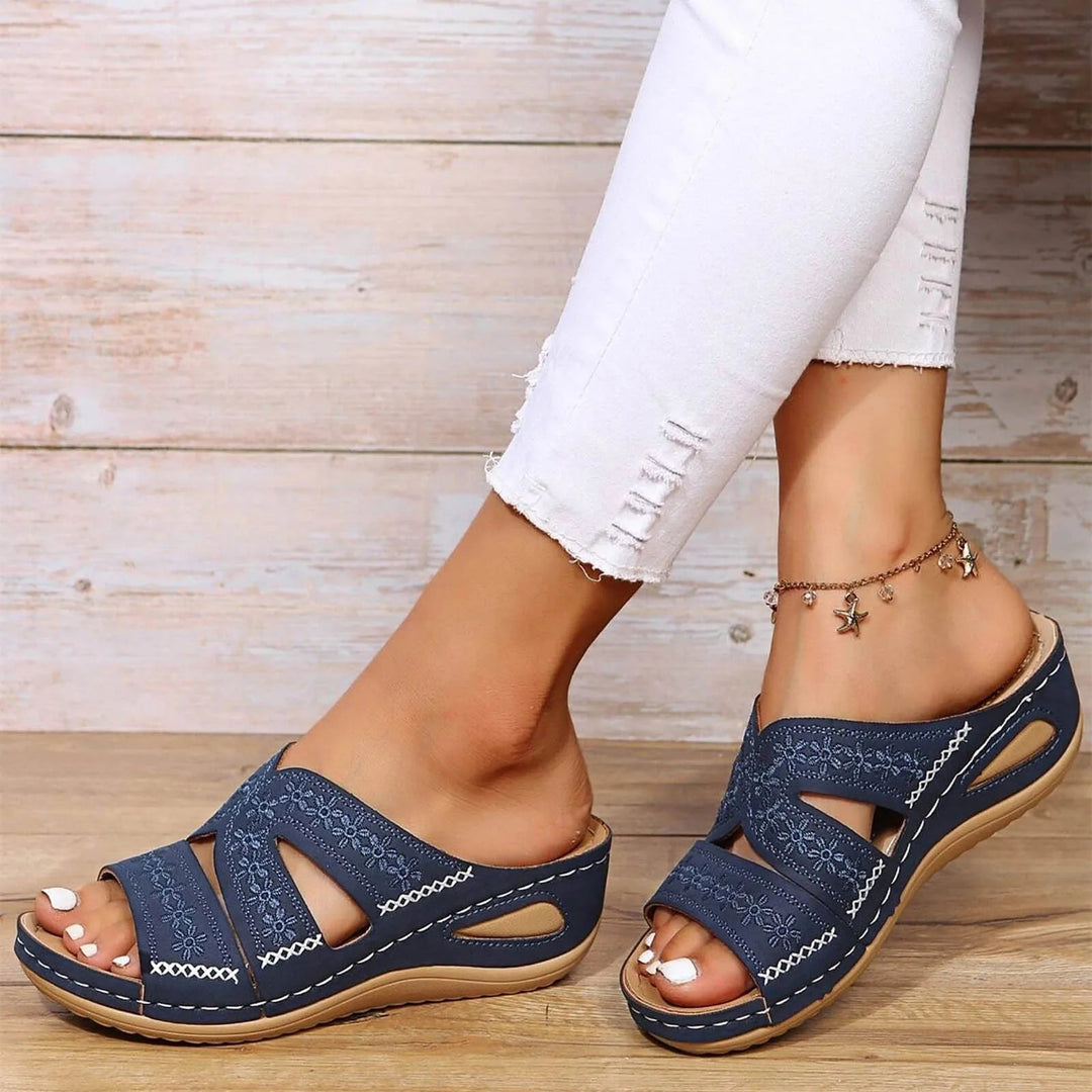 Navy blue adjustable wedge platform slides with embroidered straps and white contrast stitching