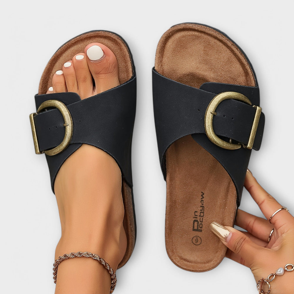 Top view of black and beige buckle slide sandals with cork sole