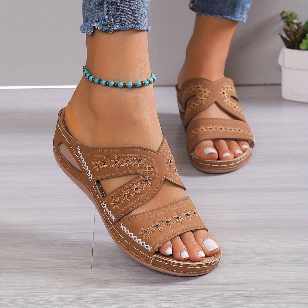 Tan embroidered orthopedic sandals with layered straps and white decorative stitching