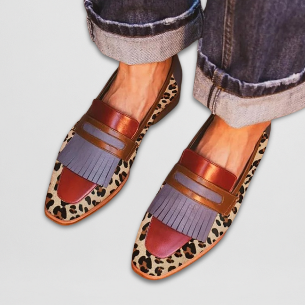 Overhead view of leopard print loafers with orange toe, purple fringe, and colorblock straps