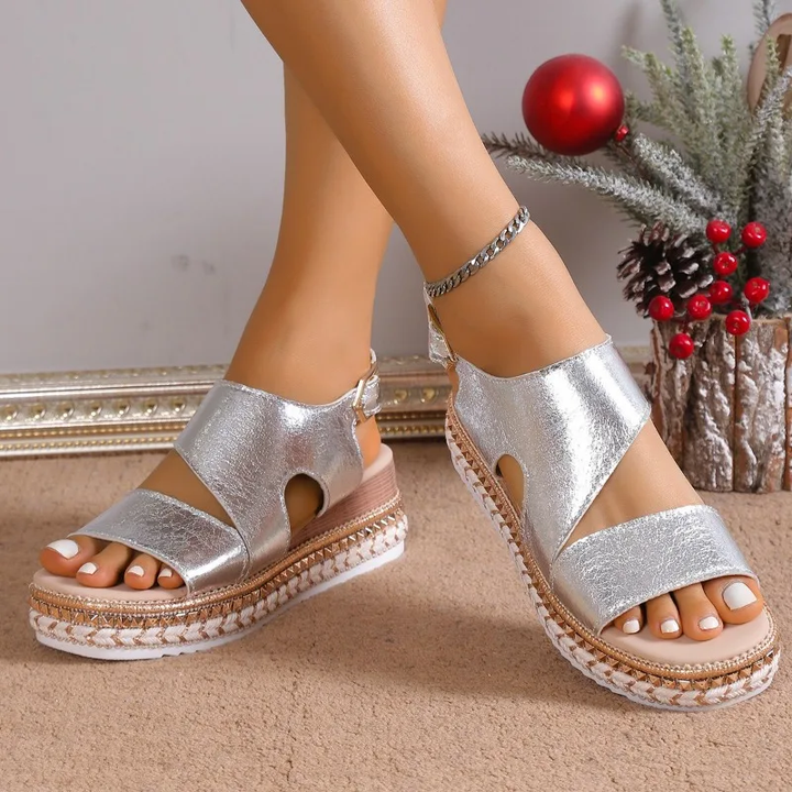 Silver metallic platform sandals with chain ankle strap and braided sole detail