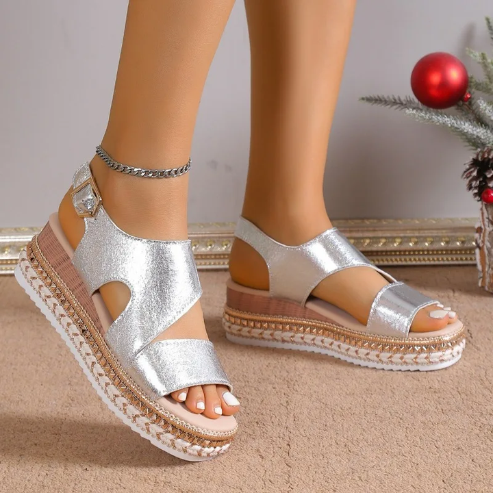 Silver metallic platform sandals with ankle strap and textured sole, front view