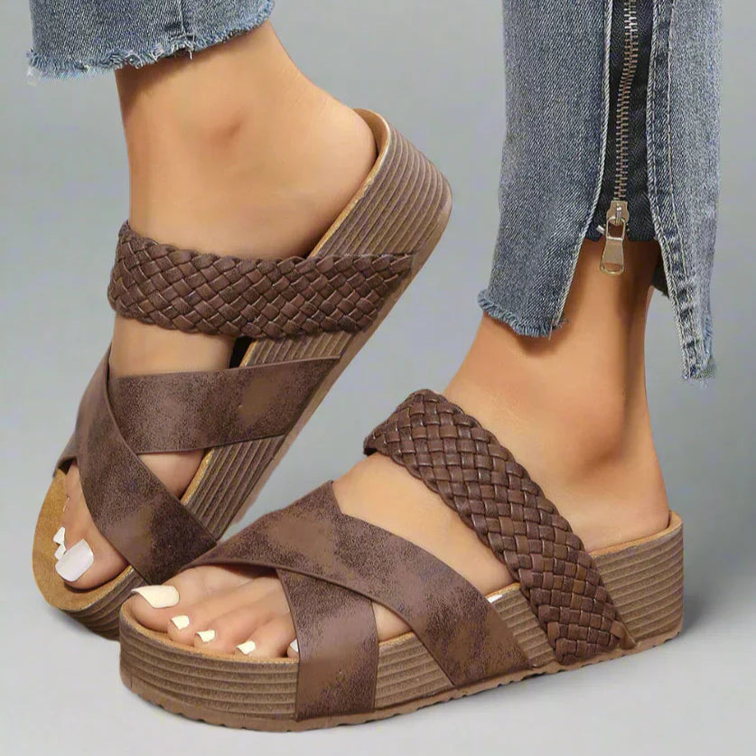 Brown woven crossover strap platform sandal with ribbed sole worn on foot