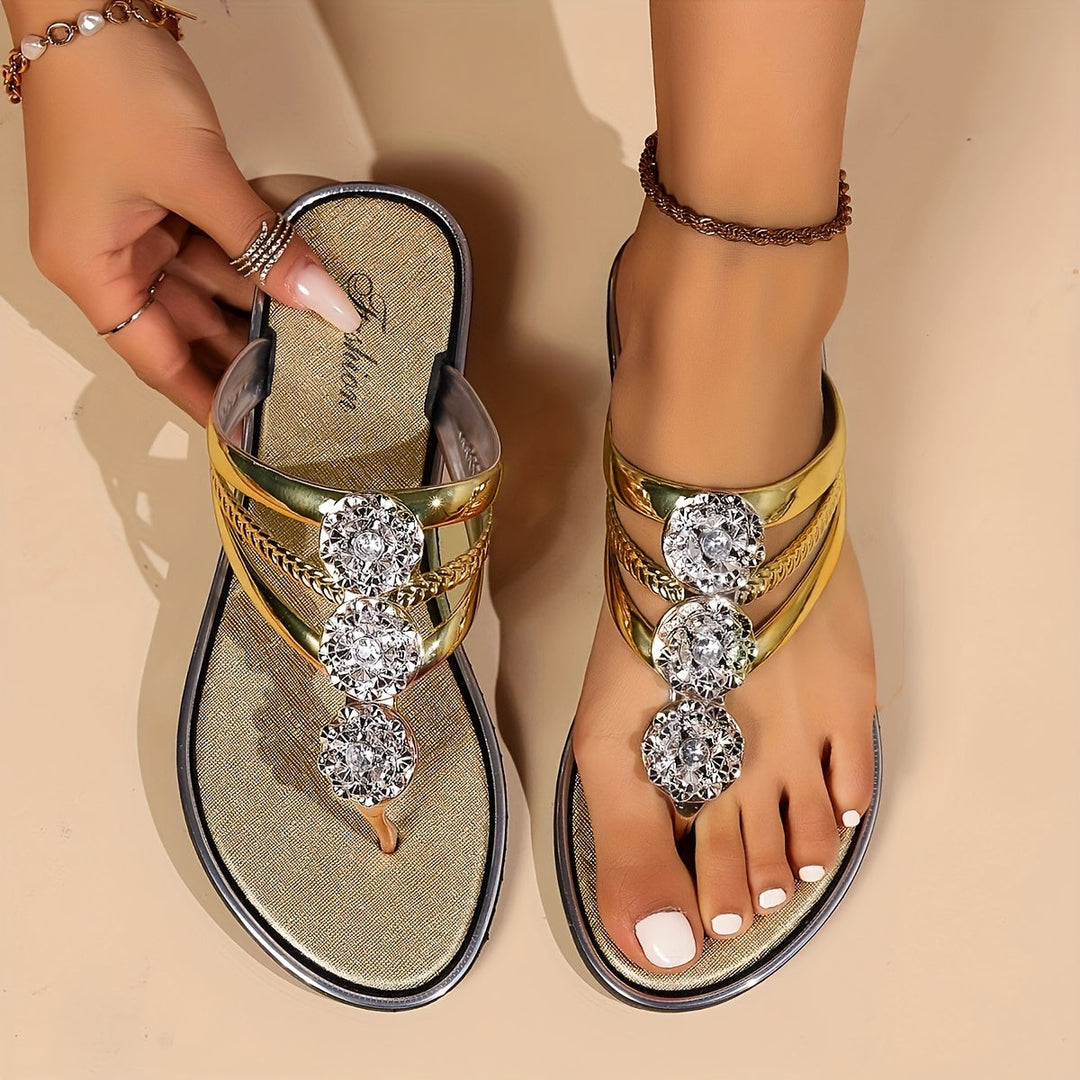 Gold metallic thong sandals with rhinestone t-strap and decorative crystal accents